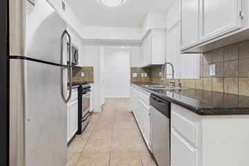 Los Angeles apartment for rent - A kitchen with white cabinets and a black fridge.