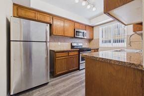 Los Angeles apartment for rent - A kitchen with a stainless steel refrigerator and wooden cabinets.