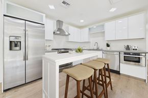 Los Angeles apartment for rent - A modern kitchen with white cabinets and a stainless steel refrigerator.