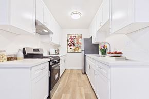 Arleta apartment for rent - A kitchen with white cabinets and appliances.
