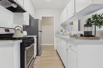North Hills apartment for rent - A kitchen with white cabinets and a black stove top.