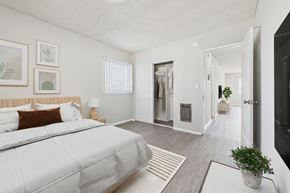 Garden Grove apartment for rent - A bedroom with a large bed and a plant on the table.
