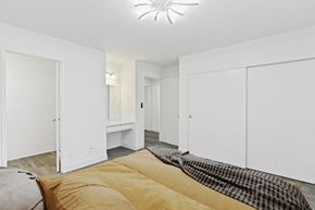 Bellflower apartment for rent - a bedroom with white closets and a large bed