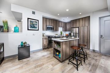 Culver City townhouse for rent - A kitchen with a bar stool and a fridge.