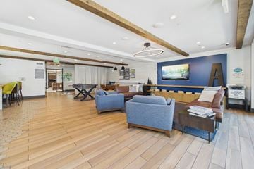 Culver City townhouse for rent - A living room with a blue couch and a television on the wall.