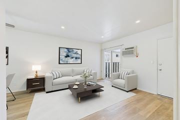 Mission Hills apartment for rent - A living room with a white couch, a coffee table, and a painting on the wall.