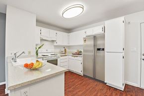 Placentia apartment for rent - a kitchen with white cabinets and stainless steel appliances