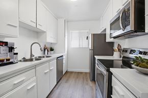 Los Angeles apartment for rent - A modern kitchen with white cabinets and stainless steel appliances.