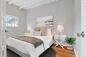 Marina Del Rey townhouse for rent - a bedroom with a bed and a white table with two lamps