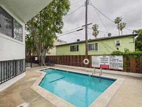 Los Angeles apartment for rent - A pool with a sign in front of a green house.