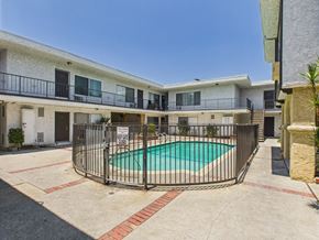 North Hills apartment for rent - A pool surrounded by a fence in front of a building.