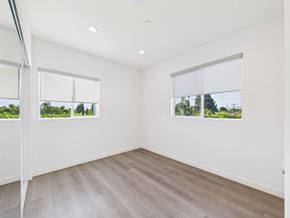 Valley Village apartment for rent - A room with a white wall and a window with a view of trees.
