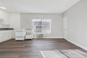 Bellflower apartment for rent - A kitchen with white appliances and a window with blinds.