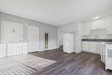 Bellflower apartment for rent - A kitchen with white cabinets and a wooden floor.