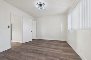 Bellflower apartment for rent - A room with a white ceiling and wooden flooring with two doors.