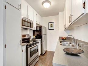 Los Angeles apartment for rent - A kitchen with white cabinets and a black countertop.