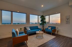 Los Angeles apartment for rent - A living room with a blue couch and a large window overlooking the city.