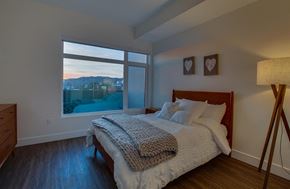 Los Angeles apartment for rent - A bedroom with a large bed and a view of the mountains outside the window.