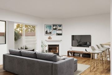 Sherman Oaks apartment for rent - A grey couch sits in front of a fireplace in a modern living room.