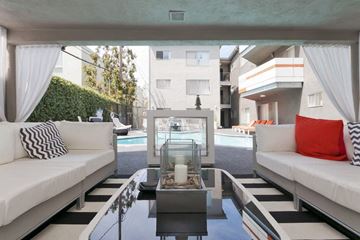 Brentwood apartment for rent - A modern living room with a pool table and a glass table with candles on it.