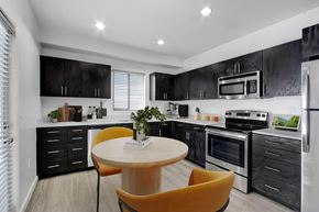Ventura apartment for rent - a kitchen with black cabinets and white appliances