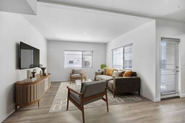 Ventura apartment for rent - A modern living room with a wooden chair and a grey sofa.