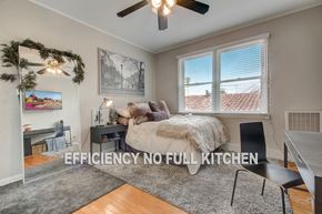 Los Angeles apartment for rent - a bedroom with a bed and a desk and a ceiling fan