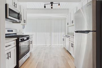 Culver City townhouse for rent - A modern kitchen with white cabinets and stainless steel appliances.