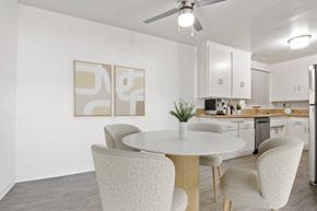 Beverly Hills apartment for rent - a kitchen with white cabinets and a white table and chairs