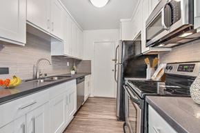 West Hollywood apartment for rent - A kitchen with white cabinets and a black stove top oven.