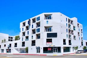 Los Angeles apartment for rent - a white apartment building with balconies and a red and white sign on the side of the
