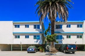 Santa Monica apartment for rent - A tall palm tree stands in front of a white building with blue trim.