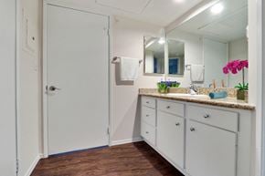 Los Angeles apartment for rent - A white bathroom with a wooden floor and a white door.