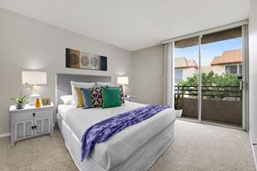 Los Angeles apartment for rent - A bedroom with a large bed and a view of the outside.