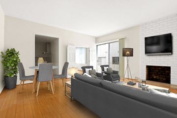 Los Angeles apartment for rent - A living room with a grey couch, a fireplace, and a television mounted on the wall.