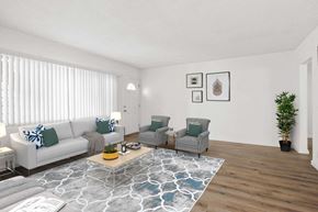 Los Angeles apartment for rent - A living room with a grey couch, two chairs, and a coffee table.