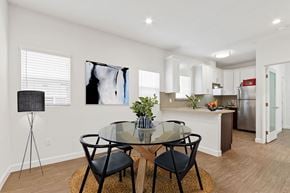 Los Angeles apartment for rent - a dining area with a glass table and chairs and a kitchen in the background