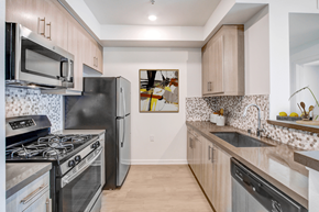 Los Angeles apartment for rent - A kitchen with a black stove top oven and a black refrigerator.at Vues on Gordon, Los Angeles, 90028 