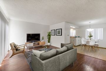 North Hills apartment for rent - A living room with a grey couch and a wooden chair.
