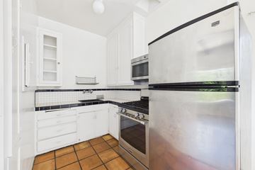 Los Angeles apartment for rent - A kitchen with a stainless steel refrigerator and black countertops.