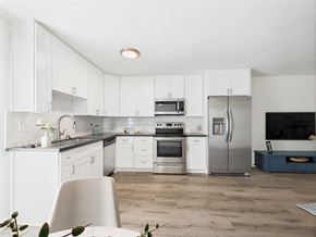 Los Angeles apartment for rent - A modern kitchen with white cabinets and stainless steel appliances.