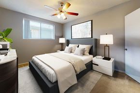 Los Angeles apartment for rent - A bedroom with a large bed, a ceiling fan, and two lamps.