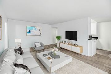 Northridge apartment for rent - A living room with a white couch, a grey coffee table, a television, and a painting on the wall.