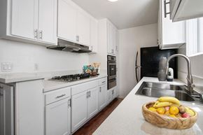 Los Angeles apartment for rent - A kitchen with white cabinets and a bowl of fruit on the counter.