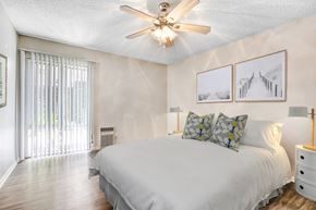 Sherman Oaks apartment for rent - A bedroom with a bed, pillows, a ceiling fan, and pictures on the wall.