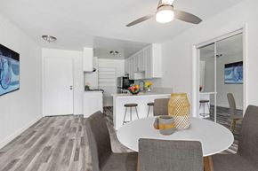 Los Angeles apartment for rent - A modern dining room with a white table and grey chairs.