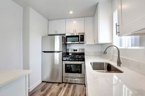 Van Nuys apartment for rent - A modern kitchen with a stainless steel refrigerator, oven, and sink.