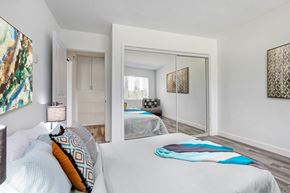 Los Angeles apartment for rent - A bedroom with a large bed and a mirror on the wall.