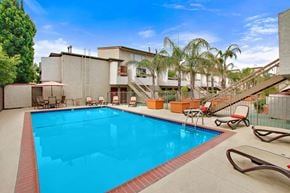 Sherman Oaks apartment for rent - A swimming pool with a red border and a metal fence surrounding it.