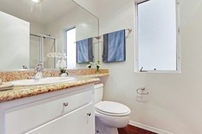Los Angeles apartment for rent - A bathroom with a toilet, sink, and mirror.